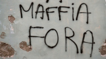 An eine Hausmauer in der korsischen Küstenstadt steht auf Korsisch geschrieben "Mafia raus!". Foto: Rachel Boßmeyer/dpa
