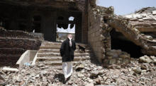 Eine Jemenitin geht durch die Trümmer eines zerstörten Gebäudes. Foto: epa/Yahya Arhab