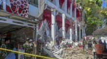 Menschen begutachten Schäden an einem Gebäude nach einem schweren Erdbeben in Manado. Behörden warnen vor einem möglichen Tsunami. Foto: epa/Basarnas / Handout