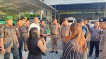 Auf dem Gelände einer Autovermietung in Phuket überprüfen Polizeibeamte Dokumente, um die Einhaltung der gesetzlichen Vorschriften durch ausländische Unternehmenseigner sicherzustellen. Foto: Khaosod English
