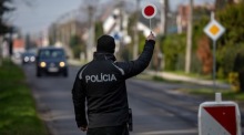 Polizisten kontrollieren ein Auto vor einem Gebäude. Archivfoto: epa/MARTIN DIVISEK