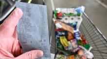 Ein Verbraucher hält nach einem Einkauf in einem Supermarkt einen Kassenzettel in der Hand. Foto: Bernd Weißbrod/dpa
