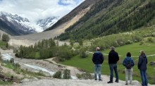 Besucher blicken auf die Geröllmassen im Lötschental, wo einst das Dorf Blatten mit 300 Einwohnern stand. Foto: dpa/Christiane Oelrich