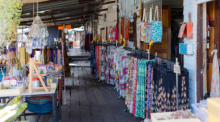 Blick über den Holzsteg mit Läden, Textilien, Souvenirs und kleinen Werkstätten am Khlong Bang Luang. Foto: Bangkok Click Studio/Adobe Stock
