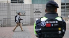 Polizisten sichern das West Kowloon Law Courts Building zum Prozessauftakt gegen die Hong Kong Alliance in Support of Patriotic Democratic Movements of China. Foto: EPA/May James