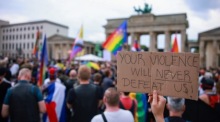 Menschen trauern vor dem Brandenburger Tor in der Nähe der Stelle, an der ein Fahrzeug in eine Menschenmenge neben der Parade-Route des Christopher Street Day (CSD) in Berlin gerast war. Foto: epa/Clemens Bilan