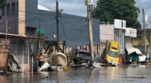Überflutete Straße mit Trümmern nach heftigen Regenfällen in Poza Rica. Dutzende Menschen kamen ums Leben, mehrere werden noch vermisst. Foto: epa/Miguel Victoria