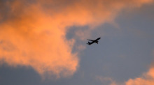 Eine Boeing 737 von TUI fly auf dem Weg von Hannover nach Palma de Mallorca zeichnet sich vor dem vom Sonnenaufgang verfärbten Morgenhimmel ab. Foto: Julian Stratenschulte/dpa