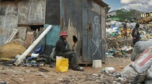 Mann vor Hütte in Armut; Hintergrund zeigt Nigeria, wo ein neuer 5-in-1 Meningitis-Impfstoff eingeführt wurde. Foto: Unsplash/Bill Wegener