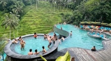 Ubud: Touristen baden in einem Pool mit Blick auf die berühmten Reisterrassen von Tegallalang. Foto: Carola Frentzen/dpa