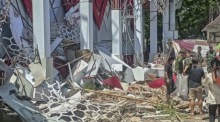 Menschen begutachten Gebäudeschäden nach starkem Erdbeben in Sulawesi. Behörden warnen vor Tsunami, Rettungskräfte sind im Einsatz. Foto: epa/Basarnas / Handout