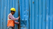 Ein indischer Arbeiter schließt das Tor einer Baustelle am Internationalen Tag der Arbeit in Mira Road. Foto: epa/Divyakant Solanki