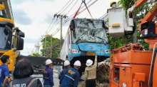 Ein Kran hebt den schwer beschädigten Linienbus nach dem Unfall auf der Lat Phrao Road zur Bergung an. Bild: JS100 Radio