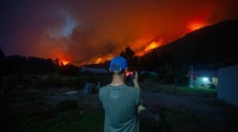 Ein Mann fotografiert einen Waldbrand in El Hoyo, während sich Feuer in Patagonien ausbreiten und tausend Hektar zerstören. Foto: epa/Matias Garay