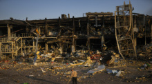 Ein Mann fegt die Trümmer neben einem Einkaufs- und Unterhaltungszentrum zusammen, nachdem es durch einen russischen Raketenangriff am 9. Mai 2022 zerstört wurde. Foto: Francisco Seco