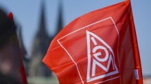 Eine Fahne der IG Metall weht vor dem Kölner Dom während eines Protesttages der Gewerkschaft. Sie fordert bessere Rahmenbedingungen für die Industrie in Deutschland. Foto: Christopher Neundorf/epa/dpa