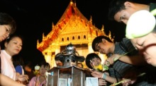Mit Blumen und Kerzen in den Händen umrunden Buddhisten am Makha-Bucha-Tag dreimal den Tempel. Foto: epa/Narong Sangnak