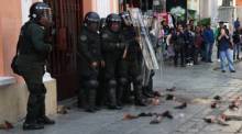 Demonstranten werfen während einer Demonstration in La Paz Kuhteile auf Bereitschaftspolizisten. Foto: epa/Luis Gandarillas