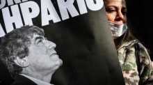 Die Frau hält ein Transparent mit einem Bild des türkisch-armenischen Journalisten Hrant Dink. Foto: epa/Sedat Suna