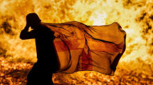 Ein junger Mann trägt eine nordirische Fahne am brennenden Craigyhill-Feuer der Loyalisten anlässlich der Feierlichkeiten zum Orangemen's Day. Archivfoto: Liam Mcburney/PA Wire/dpa