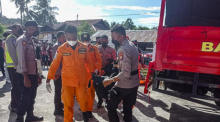 Die nationale indonesische Such- und Rettungsbehörde (BASARNAS) zeigt Retter, die einen Leichensack mit der Leiche eines Opfers eines LKW-Unfalls in Manokwari tragen. Foto: epa/Basarnas Handout