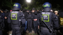 Demonstranten stehen während einer sogenannten polizeilichen Umschließung zusammen. Foto: Sebastian Willnow/dpa