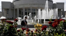 Ein Mann geht an einem Springbrunnen vor der Russischen Nationalbibliothek in St. Petersburg vorbei. Foto: EPA/Anatoly Maltsev