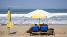 Touristen genießen den Strand von Kuta auf Bali. Die indonesische Ferieninsel erwartet bis Ende 2025 rund sieben Millionen internationale Besucher. Foto: epa/Made Nagi