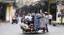 Ein Verkäufer geht auf einer Straße in Hanoi, Vietnam. Foto: epa/Luong Thai Linh