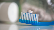 Eine sogenannte Zahnputztablette liegt im Badezimmer auf einer Zahnbürste. Zahnpasta auf die Bürste geben, Wasser drüber und ab in den Mund damit. Foto: Fernando Gutierrez-Juarez/dpa