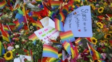 Blumen und Regenbogenfahnen liegen nahe dem Tatort nach der Schießerei vor dem London Pub im Zentrum von Oslo. Foto: epa/Martin Solhaug Standal