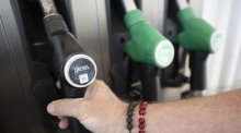 Ein Mann nimmt einen Zapfhahn an der Trigema-Tankstelle in Burladingen in die Hand. Foto: Marijan Murat/dpa
