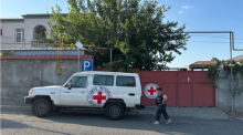 Ein Fahrzeug des Internationalen Roten Kreuzes steht vor einem Haus. Foto: Marut Vanyan/dpa