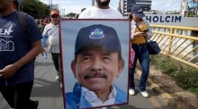 Ein Demonstrant marschiert mit einem Bild des nicaraguanischen Präsidenten Daniel Ortega. Foto: EPA-EFE/Jorge Torres