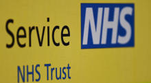 NHS Trust-Branding vor einem NHS-Krankenhaus in London. Foto: epa/Andy Rain