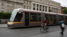 Radfahrer passiert eine Straßenbahn des Luas im Stadtverkehr von Dublin. Foto: epa/Adam Vaughan