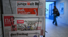 Die Printausgabe der Zeitung "taz" vom 17. Oktober 2025 steckt zwischen anderen Zeitungen. Foto: Soeren Stache/dpa
