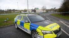 Ein Polizeiauto am abgesperrten Tatort einer Schießerei in einem Sportzentrum in Omagh. Foto: epa/Mark Marlow