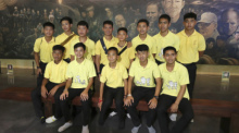 Die 12 Jungs der Fußballmannschaft der „Wild Boars“ aus Mae Sai und ihr ehemaliger Fußballtrainer Ekkapol Chanthawong (4.v.l.h.), die 2018 zusammen aus der überfluteten Tham-Luang-Höhle gerettet worden waren. Foto: Sakchai Lalit/Ap/dpa
