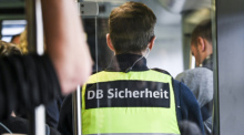 Ein Mitarbeiter der DB-Sicherheit steht in einem Zug. Foto: Jens Kalaene/dpa