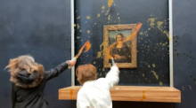 Zwei Umweltaktivisten des Kollektivs «Riposte Alimentaire» (Vergeltung für Lebensmittel) bewerfen im Pariser Louvre das Gemälde «Mona Lisa» von Leonardo da Vinci mit Suppe (Videostandbild). Foto: David Cantiniaux/Afptv/afp/dpa