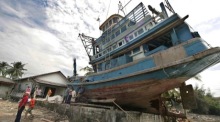 Ein thailändisches Fischerboot liegt im Dorf Ban Nam Khem, nachdem es vom Tsunami am 26. Dezember 2004 weit ins Landesinnere geschleudert worden war. Foto: epa/Ciro Fusco