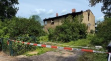Blick auf den Brandort in Friesack. Nach einem Brand im brandenburgischen Friesack sind drei Leichen in dem ausgebrannten Haus entdeckt worden. Das teilte ein Sprecher der Polizei mit. Foto: Christian Pörschmann/dpa