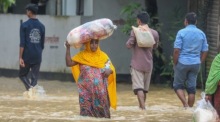 Die Leute waten durch das Hochwasser in einem vom Hochwasser betroffenen Gebiet in Burichong, Bezirk Comilla. Foto: epa/Monirul Alam