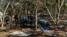 Israelische Soldaten stehen neben einem verlassenen Auto auf dem Gelände des Supernova-Wüstenmusikfestivals, nachdem es den israelischen Streitkräften gelungen ist, die Gegend um Re'im zu sichern. Foto: Ilia Yefimovich/dpa
