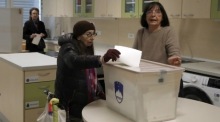 Wählerin gibt in Ljubljana ihre Stimme bei der Parlamentswahl ab, überschattet von Berichten über mutmaßliche Einflussnahme auf den Urnengang. Foto: epa/Antonio Bat