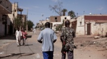 Leute laufen durch eine Straße in Omdurman im Sudan. Foto: epa/Sara Creta