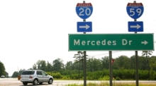 in Mercedes der M-Klasse biegt hinter einem Straßen-Schild zum Mercedes-Werk ab. Foto: Harry Melchert/dpa