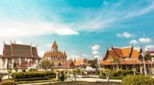 Der prachtvolle Loha Prasat in Bangkok erstrahlt mit seinen goldenen Spitzen unter einem strahlend blauen Himmel inmitten gepflegter Gartenanlagen. Foto: Unsplash/Alejandro Cartagena