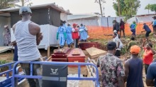 Angehörige von Ebola-Opfern warten vor einem Krankenhaus in Mongbwalu auf die Übergabe der Verstorbenen. Foto: EPA/Dieudonne Dirole
